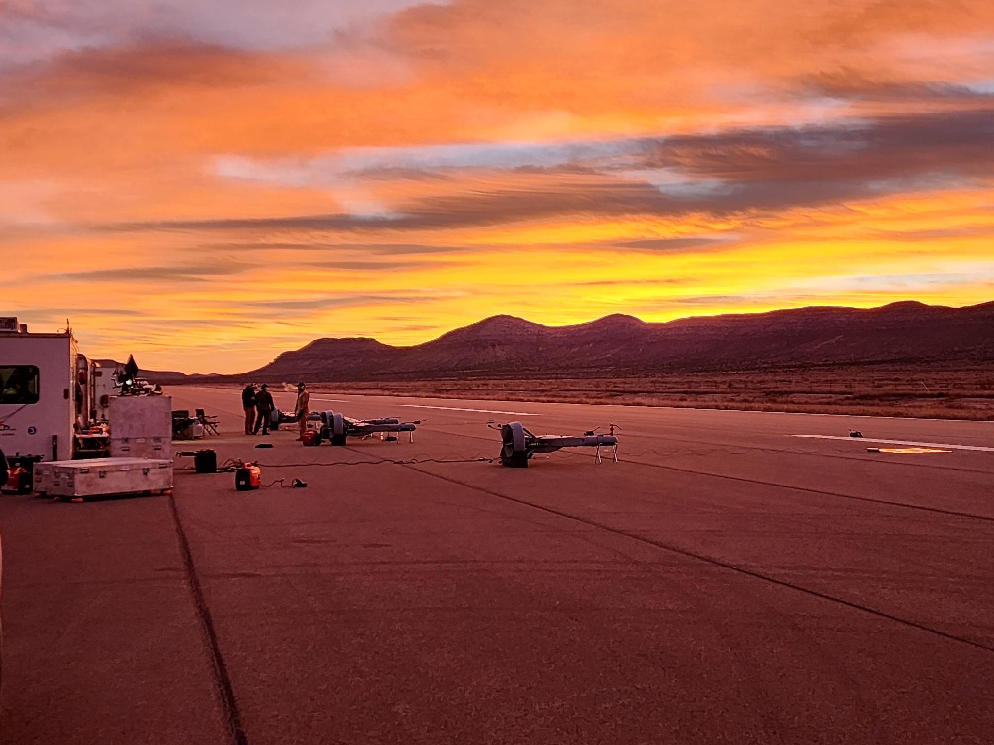 Drone equipment on airfield at sunset with mountains
