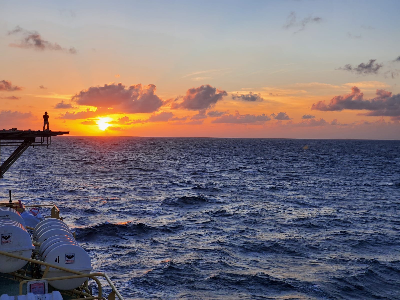 Operator watching sunset over the ocean from vessel