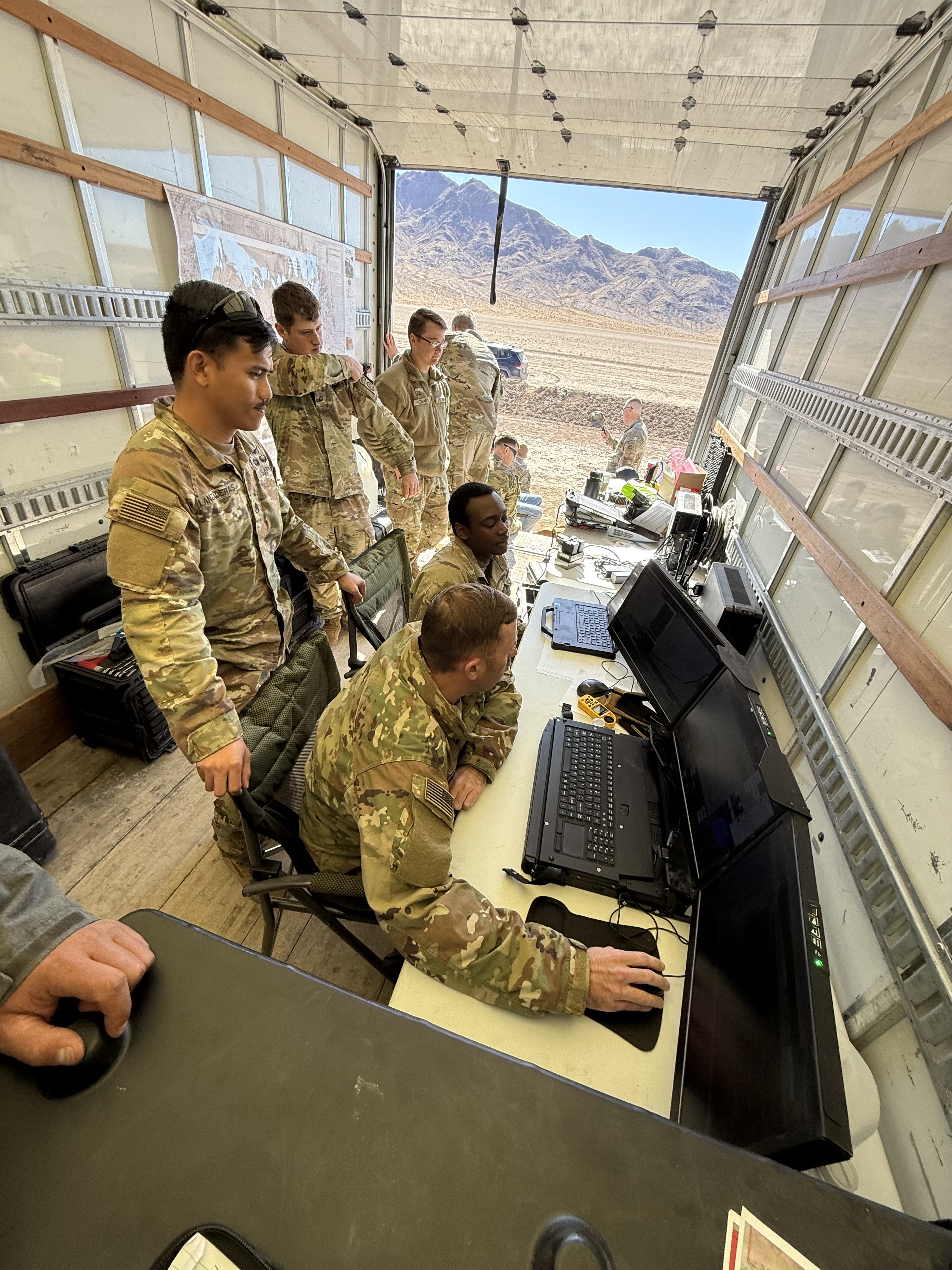 Military personnel in mobile command unit during field training